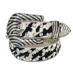 Unisex black-and-white leather belt embellished with sparkling clear rhinestones and an intricately detailed silver-tone horseshoe buckle. Add a touch of luxury and sparkle to your outfit with the Unisex Black And White Leather Belt from Real Rhinestone. Featuring a sleek black and white leather strap, this stylish belt is adorned with Black and Golden Color diamond rhinestones, creating a bold and glamorous look. The Silver  Tone buckle, decorated with designs, enhances the design with extra shine and sophistication. Designed for versatility and comfort, this belt is perfect for both casual and dressy occasions. Whether you are looking to complete a hip-hop-inspired outfit, make a statement at an event, or simply add some extra bling to your wardrobe, this belt is the perfect accessory. Its adjustable fit ensures all-day comfort, while the high-quality materials guarantee durability and long-lasting wear. Elevate your style effortlessly with the Unisex Black And White Leather Belt. Whether you are hitting the stage, going out with friends, or just upgrading your everyday look, this belt is a must-have. Order now from Real Rhinestone and bring some diamond-studded brilliance to your collection. Material: Premium Leather Rhinestone: Luxury Hand-Set High-Gloss Crystal Diamond Embellishments Buckle Type: Classic horseshoe Zinc Buckle Set Featuring Engraved Design & Sparkling Rhinestones Width: 4cm (1.5 Inch) Style: Streetwear, Cowboy, Western, Partywear, Festivals & Performances, Fashion, Hip Hop, Bling, Diamond Belt Measurement: Please note that measurements may vary by 1-2 cm. Our belts are measured from the fold where the buckle is attached to the middle hole. For the best fit, we recommend measuring a belt you already own from the fold to the hole you use most frequently. Ideally, the belt should be worn on the third hole for optimal fit and comfort.