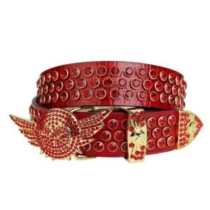 Unisex Red Textured Leather Belt Highlighted With Red Rhinestones And Polished Gold wing Buckle Add a touch of luxury and sparkle to your outfit with the Unisex Red Leather Belt from Real Rhinestone. Featuring a sleek Red leather strap, this stylish belt is adorned with Red Color diamond rhinestones, creating a bold and glamorous look. The Gold buckle, decorated with red rhinestones, enhances the design with extra shine and sophistication. Designed for versatility and comfort, this belt is perfect for both casual and dressy occasions. Whether you are looking to complete a hip-hop-inspired outfit, make a statement at an event, or simply add some extra bling to your wardrobe, this belt is the perfect accessory. Its adjustable fit ensures all-day comfort, while the high-quality materials guarantee durability and long-lasting wear. Elevate your style effortlessly with the Unisex Red Leather Belt. Whether you are hitting the stage, going out with friends, or just upgrading your everyday look, this belt is a must-have. Order now from Real Rhinestone and bring some diamond-studded brilliance to your collection. Material: Premium Leather Rhinestone: Luxury Hand-Set High-Gloss Crystal Diamond Embellishments Buckle Type: Classic wing Zinc Buckle Set Featuring Engraved Design & Sparkling Rhinestones Width: 4cm (1.5 Inch) Style: Streetwear, Cowboy, Western, Partywear, Festivals & Performances, Fashion, Hip Hop, Bling, Diamond Belt Measurement: Please note that measurements may vary by 1-2 cm. Our belts are measured from the fold where the buckle is attached to the middle hole. For the best fit, we recommend measuring a belt you already own from the fold to the hole you use most frequently. Ideally, the belt should be worn on the third hole for optimal fit and comfort.