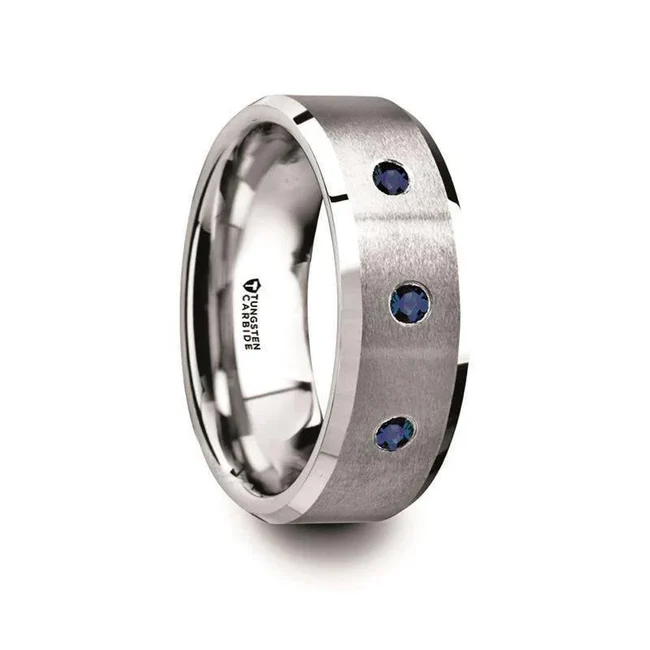 NAUTILUS Tungsten Satin Finished Center Polished Beveled Edges Men’s Wedding Band with 3 Blue Sapphires - 8mm The center of this stunning flat-profiled, satin finished Tungsten Carbide wedding band design by Thorsten features polished beveled edges and three brilliant Blue Sapphire gemstones, the most precious, valuable, and gorgeous gem in the world, a favorite of royalty and symbolic of wisdom, protection, and good fortune. Engraving available! See Pictures for Details. Does Not Delay Order. Includes Thorsten Lifetime and Lifetime Sizing Warranty (excluding re-engraving). Available in an 8mm width. Tungsten Carbide is the newest and strongest metal for jewelry that does not scratch easily. Comfort Fit – domed interior band slides over the knuckle easier with less friction. Brand: Thorsten Metal Type: Tungsten CarbideColor: Blue|Silver Finish: Brushed Style: Beveled Stones: Blue Sapphire SKU: T5980-BPBS
