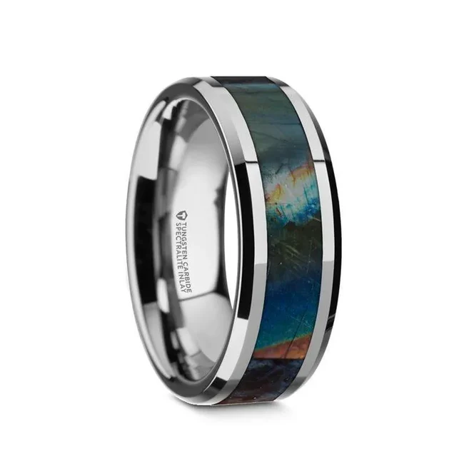 This amazing Tungsten Carbide ring by Thorsten features an inlay of high-grade Natural Spectrolite, a semi-precious gemstone from Finland and known for its dazzling display of color when illuminated. Natural Spectrolite is also regarded as a healing stone and has been recognized to aid those seeking peace and tranquility. Engraving available! See Pictures for Details. Does Not Delay Order. Includes Thorsten Lifetime and Lifetime Sizing Warranty (excluding re-engraving). Available in an 8mm width. Tungsten Carbide—the newest and strongest metal for jewelry that does not scratch easily. Note, inlay is protected by a resin that can be scratched. Each piece of Natural Spectrolite may differ from the picture. Comfort Fit – domed interior band slides over the knuckle easier with less friction. Brand: Thorsten Metal Type: Tungsten Carbide Color: Multi-Colored|Silver Finish: Polished Style: Beveled Stones: None SKU: W1549-TCBD