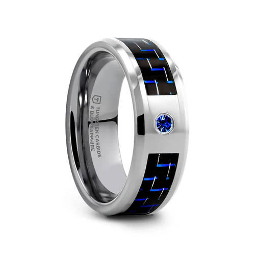 This elegant and sophisticated ring by Thorsten incorporates a Blue Sapphire and is made from one piece of polished Tungsten Carbide by cutting a channel almost all the way around the ring, where a blue and black carbon fiber is inlaid. Engraving available! See Pictures for Details. Does Not Delay Order. Includes Thorsten Lifetime and Lifetime Sizing Warranty (excluding re-engraving). Available in 8mm width. Other widths are available as a custom order. Tungsten Carbide the newest and strongest metal for jewelry that does not scratch easily. Comfort Fit – domed interior band slides over the knuckle easier with less friction. Brand: Thorsten Type: Tungsten Carbide Color: Black|Blue|Silver Finish: Polished Style: Beveled|Carbon Fiber Inlay|Gemstones Stones: Blue Sapphire SKU: W2960-TCBD