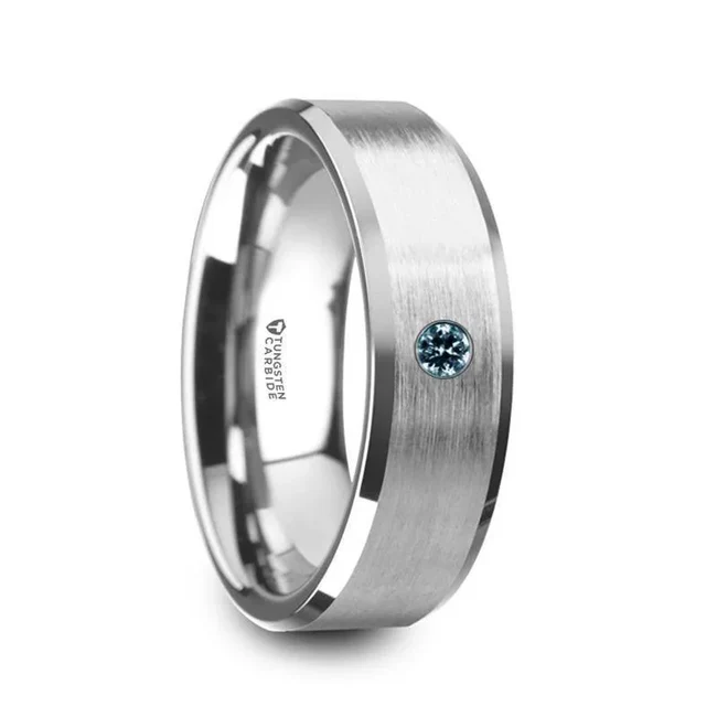 MOORE Flat Brushed Center Polished Beveled Edges Men’s Tungsten Wedding Band with Blue Diamond Setting - 6mm or 8mm A single 0.05 carat blue diamond is the main attraction on this masculine Tungsten Carbide wedding band design by Thorsten. The brushed center provides a smooth, clean look and the beveled edges are polished to perfection. Engraving available! See Pictures for Details. Does Not Delay Order. Includes Thorsten Lifetime and Lifetime Sizing Warranty (excluding re-engraving). Available in 6mm and 8mm widths for couples who want a matching set. Tungsten Carbide is the newest and strongest metal for jewelry that does not scratch easily. Comfort Fit – domed interior band slides over the knuckle easier with less friction. Brand: Thorsten Metal Type: Tungsten Carbide Color: Blue|SilverFinish: Brushed Style: Beveled|Diamonds Stones: Blue Diamond SKU: W5979-TCBS